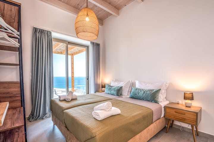 Bedroom 2 with two single beds, ensuite bathroom and balcony with sea view