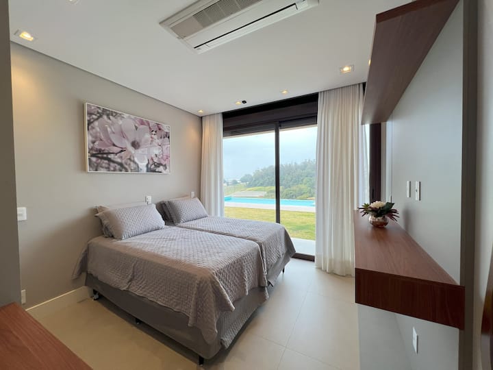 Quarto com com duas camas de solteiro e uma cama auxiliar.