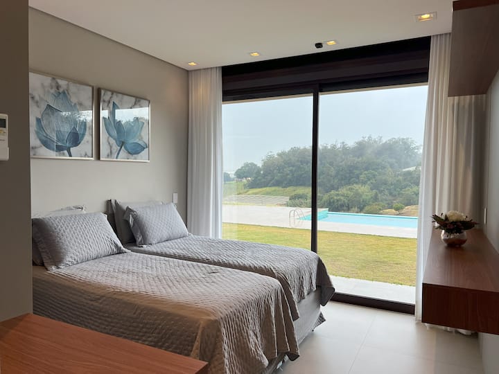 Quarto com com duas camas de solteiro e uma cama auxiliar.