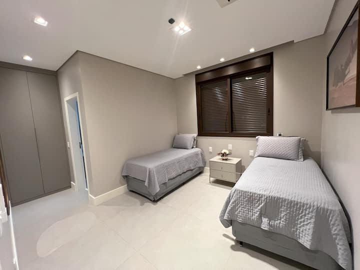 Quarto com com duas camas de solteiro e duas camas auxiliares.