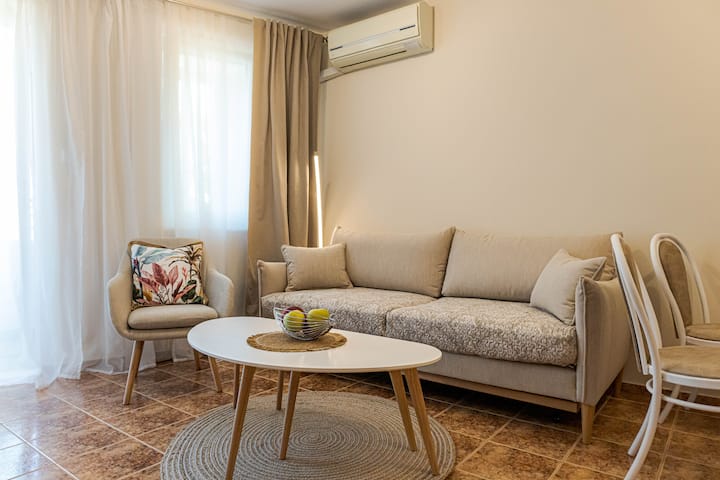 Gemütliches Wohnzimmer mit einem bequemen Ecksofa und stilvollen Akzenten, ideal zum Entspannen, nachdem du die Stadt erkundet hast.