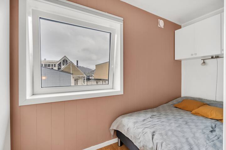 El rincón para dormir es acogedor y semiprivado, con una cómoda cama y una ventana con vistas a las montañas del continente. Un lugar tranquilo para relajarse y descansar después de un día completo en la ciudad o en la naturaleza.