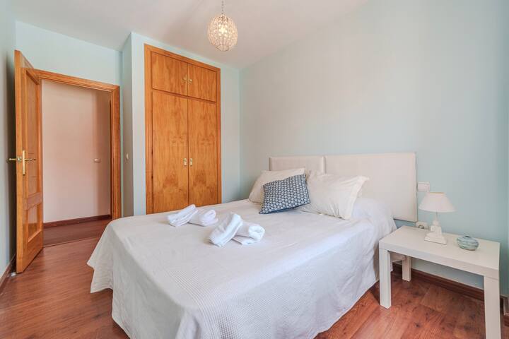 Cama doble del dormitorio 3 con cojines azules.