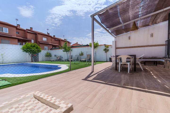 Jardín con piscina privada y césped artificial.