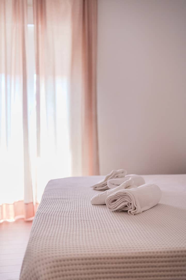 Ropa de cama blanca y toallas preparadas en el dormitorio 1.