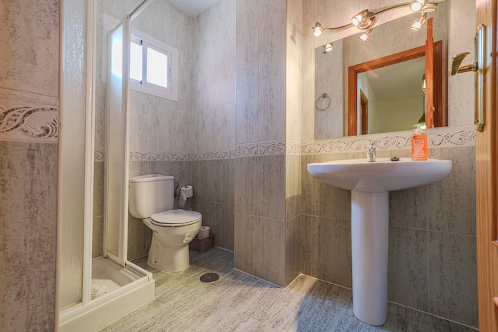 Baño 2 con espejo y azulejo claro.