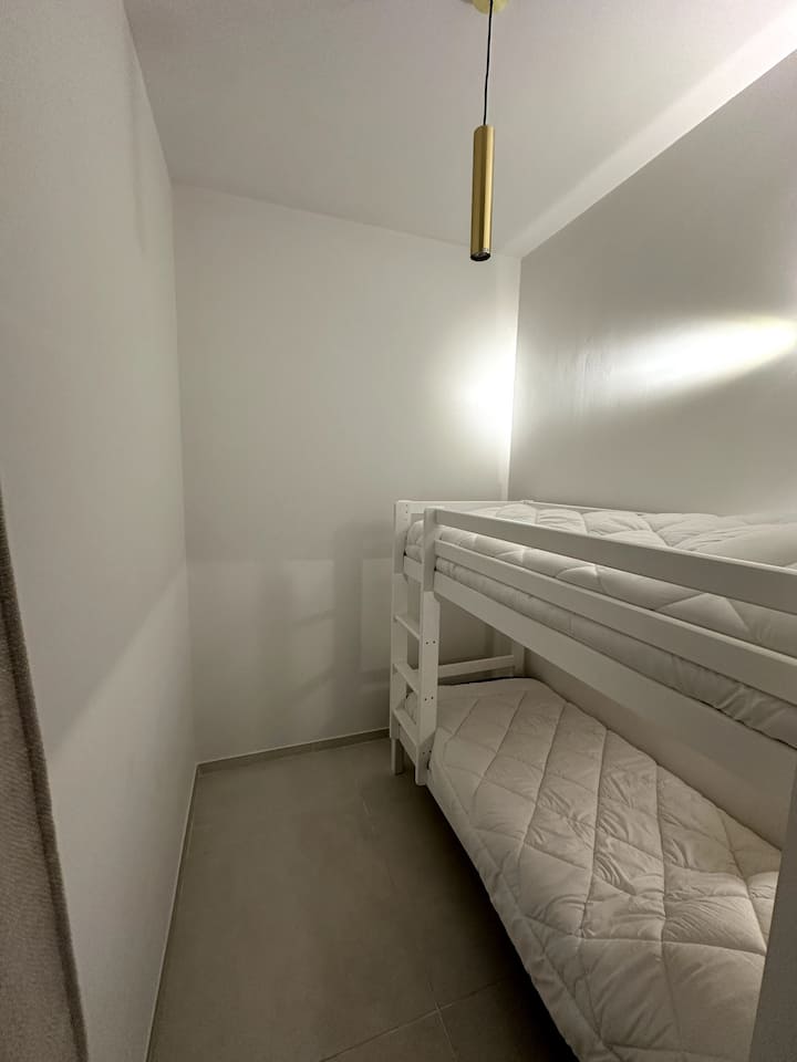 Ხის ოთახი ფანჯრის გარეშე, რომელიც იტევს 2 ბავშვს ან მოზარდს.
Ქსოვილის ფარდა იზოლირებს ხის სახლის ოთახს დანარჩენი ბინისგან.
2 საწოლი 80x190