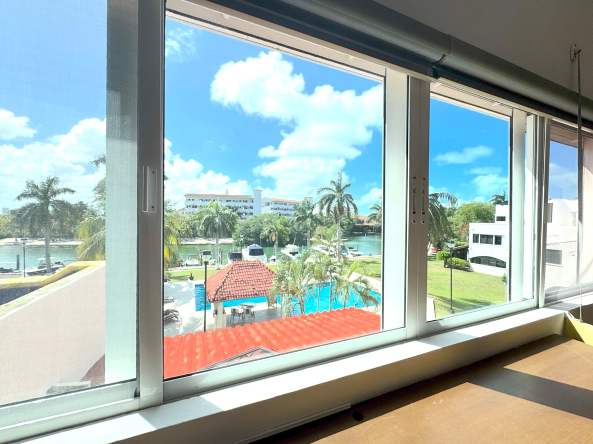 ห้องนอนใหญ่สไตล์โมเดิร์นที่มีการตกแต่งที่มีสไตล์และเตียงคิงไซส์ตั้งอยู่ในตำแหน่งที่สมบูรณ์แบบเพื่อชมวิวสระว่ายน้ำและท่าจอดเรือที่เงียบสงบ