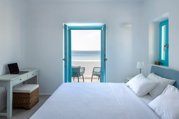 Dormitorio principal con balcón privado y vistas impresionantes a la piscina y al mar.