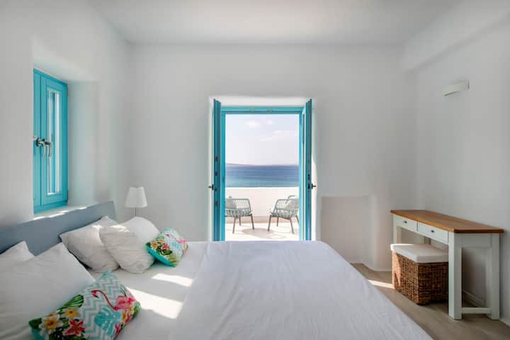 Despiértate con vistas ininterrumpidas al mar y a la piscina desde este elegante dormitorio principal con balcón privado.