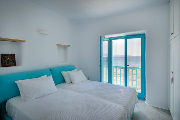 Segundo dormitorio luminoso y espacioso con vistas panorámicas al mar Egeo y a tu piscina privada.