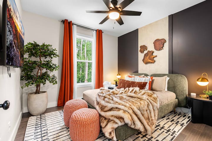  这间宁静的皇后卧室采用自然纹理和大胆的设计，配有人造毛毯、朴实的装饰和郁郁葱葱的景观，非常适合在探索阿什维尔或山毛榉山一天后放松身心