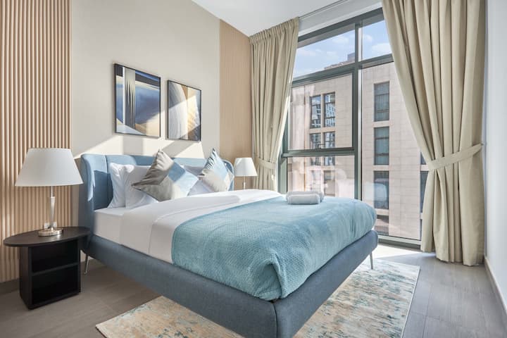 Disfruta del lujo en una cama tamaño queen con sábanas suntuosas y lámparas ambientales. Disfruta de una vista impresionante de la ventana de día y de noche. Ubicado cerca de los exuberantes espacios verdes y los exclusivos senderos para caminar de Mohammed Bin Rashid Al Maktoum City ✨