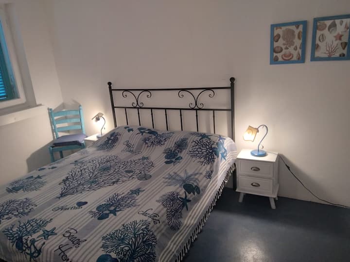 Двокреветна соба на приземје со бања на подот и поглед кон градината. Оваа соба не е опремена со клима уред, туку само со вентилатор