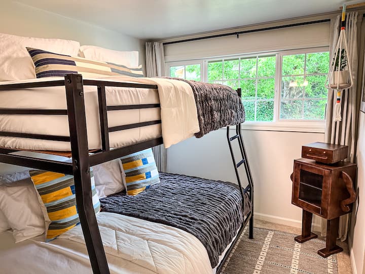 Este quarto alegre com beliches foi projetado para oferecer o máximo de conforto e boas vibrações. Com uma cama queen-size na parte inferior e uma XL completa na parte superior, ambas com mantas ultra macias e almofadas brilhantes e modernas, é um lugar aconchegante para dormir depois de um dia de aventura.