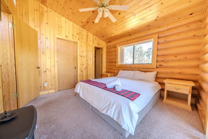 Geniet van een grote slaapkamer met kingsize bed met rustieke houten accenten en uitnodigende houten panelen. Deze kamer baadt in natuurlijk licht en biedt een rustige bergontsnapping die perfect is voor stellen of soloreizigers die op zoek zijn naar rust en ontspanning.