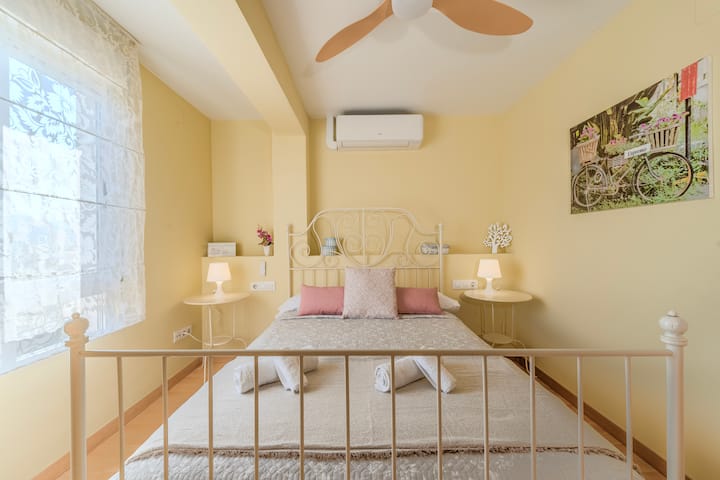 Dormitorio 1 con aire acondicionado y luz cálida.