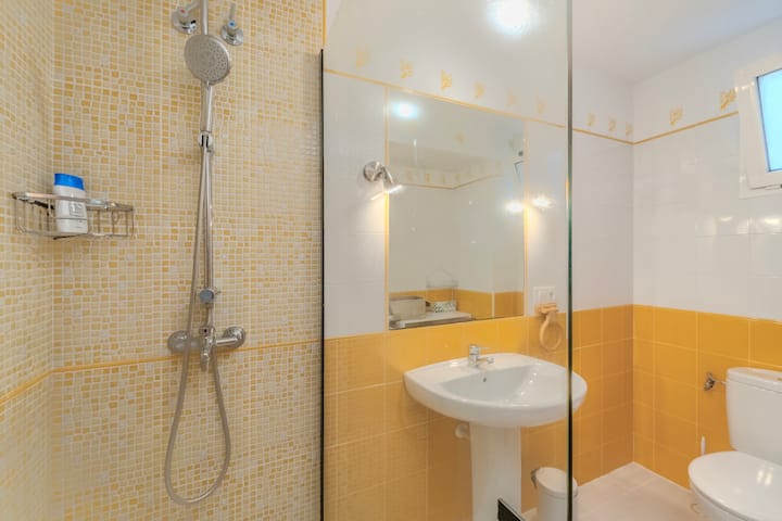 Baño 1 con ducha y azulejo amarillo alegre.