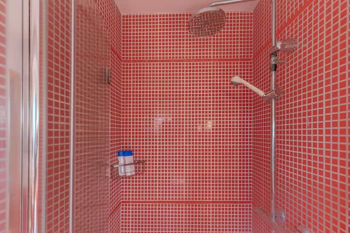Ducha del baño 2 con azulejo rojo vibrante.