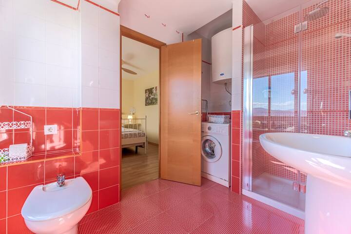 Baño 2 en rojo con ducha y mampara.