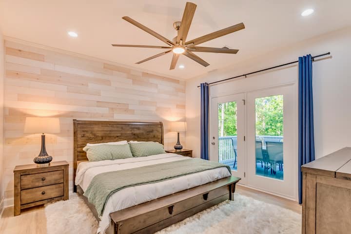 Pumzika na upumzike katika chumba cha kulala cha msingi chenye utulivu, kamili na kitanda cha kifalme, zulia la eneo la plush chini ya miguu, na chumba cha kujitegemea kwa ajili ya starehe ya ziada. Mlango tofauti wa kuingia kwenye sitaha unakaribisha asubuhi tulivu au jioni zenye utulivu hatua chache tu kutoka kitandani mwako.