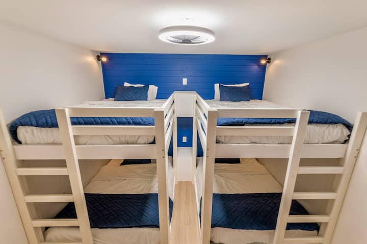 Iliyoundwa kwa ajili ya watoto au marafiki, chumba hiki cha ghorofa kina ghorofa mbili kamili, taa binafsi na maduka. Ukuta wa bluu wa bluu na ukuta kamili wa ziwa huongeza kuvutia, haiba ya majini-kamilifu kwa ajili ya kupumzika au kuota jasura za ziwa.