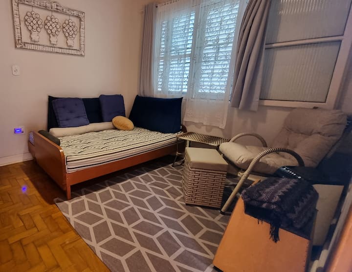 Canapé-lit futon pouvant accueillir 2 personnes supplémentaires, si nécessaire. Fauteuil, table d'appoint, télévision 42" avec Fire TV, ventilateur, pouf-coffre et panier avec hamacs à l'intérieur. Un cajón. Des étagères avec des livres, des jouets et des jeux.