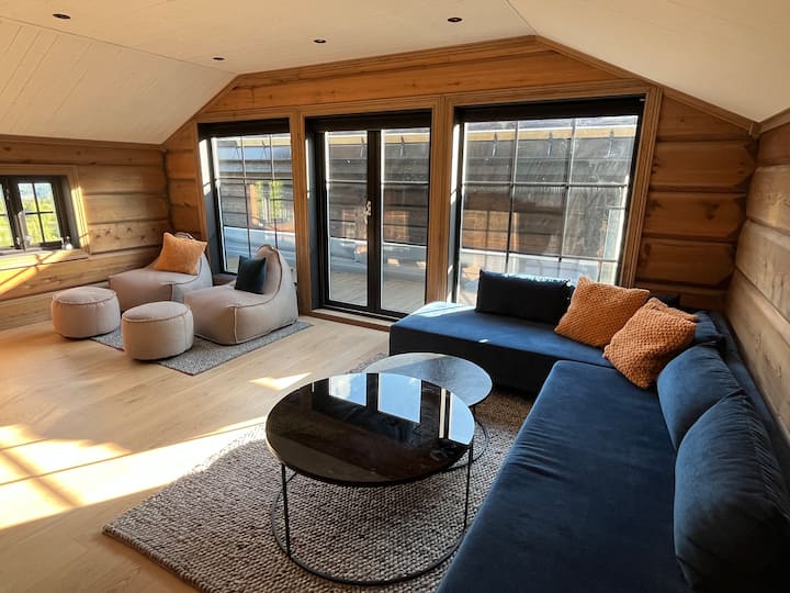 The second living room features a sleepsofa and armchairs perfect for lounging. Equipped with a 65-inch TV, Apple TV, PS5, and a premium sound system.