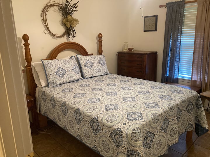 El dormitorio 3 ofrece un acogedor marco de cama de madera, decoración clásica y luz natural suave, perfecto para los huéspedes que buscan una estancia tranquila y relajante.