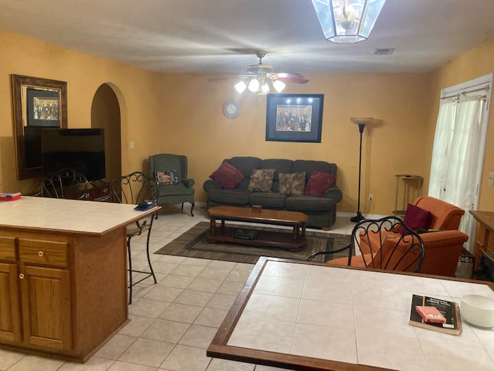 La segunda sala de estar ofrece un espacio relajado y de concepto abierto con múltiples opciones de asientos, un televisor grande y fácil acceso a la cocina, perfecto para noches de cine o reuniones informales.