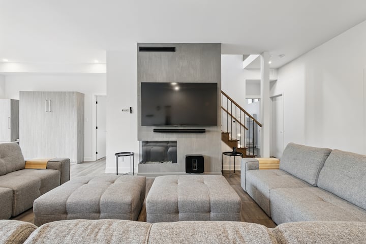 Obývačka na prízemí s masívnym gaučom, vedľa herne.