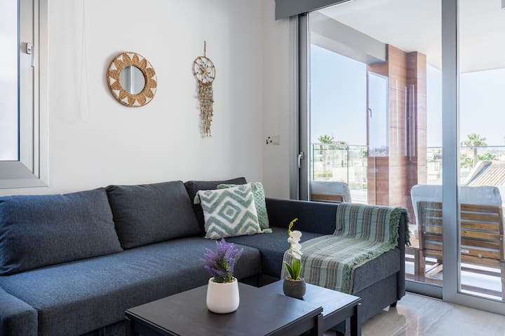 Spacious living room with a smart TV and a cozy sofa bed for extra sleeping space — comfort meets convenience!