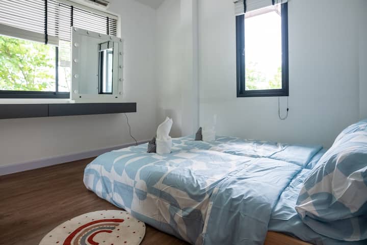 Спокойна спалня със свежи тонове и меки спални принадлежности, предназначена за спокоен детски комфорт.