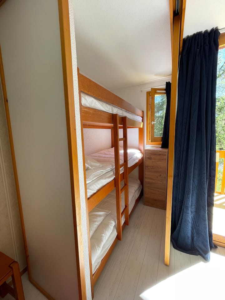 Une cabine qui se ferme à l'aide de 2 panneaux coulissants contient 3 lits superposés (pour enfants seulement).