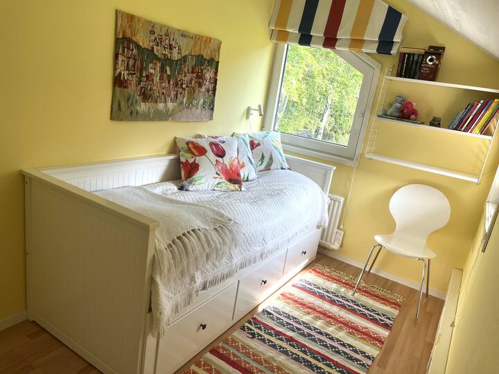 Svetlá a pekná spálňa s posteľou, ktorá má v zasunutej polohe šírku 80 cm. Ak sa vytiahne, bude to 160 cm. Potom presuňte stoličku a koberec.