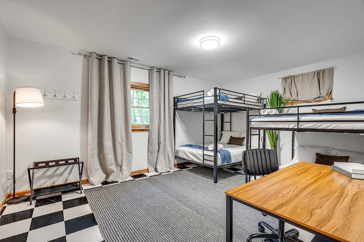 Bedroom 7 features four cozy double beds in bunk-style setup — perfect for families, kids, or a fun group getaway. With a desk area and warm lighting, it’s both playful and practical.