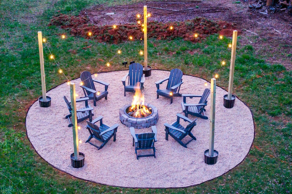 Fire pit lit at dusk with string lights aglow