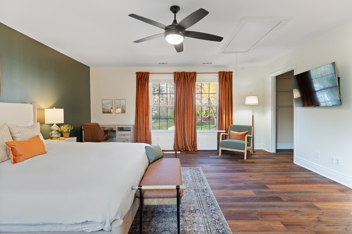 Bedroom with orange curtains and dark accent wall