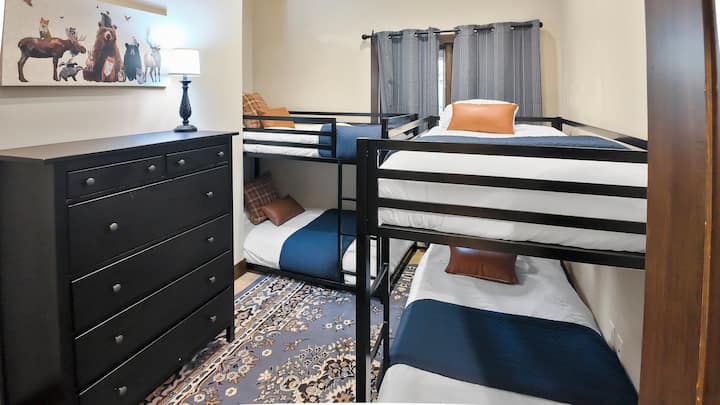 Spálňa 3 je ideálna pre rodiny alebo skupiny, pretože má dve poschodové postele pre viacerých hostí a veľkú zásuvkovú jednotku pre dostatok úložného priestoru, vďaka čomu je priestor organizovaný a pohodlný.