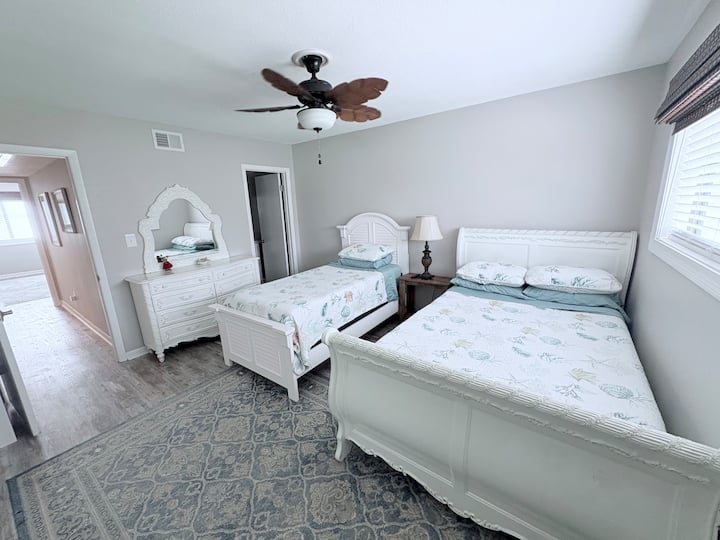 Este elegante segundo dormitorio cuenta con dos camas, una cama de tamaño completo y otra cama de tamaño doble, perfecta para familias, amigos o niños.