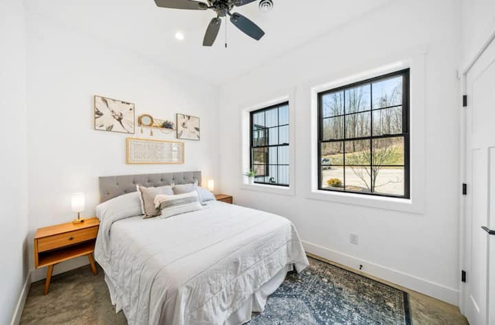Habitación de invitados luminosa y acogedora con un lujoso colchón Nectar tamaño queen, TV inteligente, ventilador de techo y escritorio para trabajar de pie, todo bañado en luz natural con un amplio armario para deshacer el equipaje fácilmente.