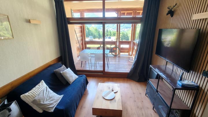 Მისაღები ოთახი გასაშლელი დივნით, დიდი ტელევიზორითა და სათავსოთი.