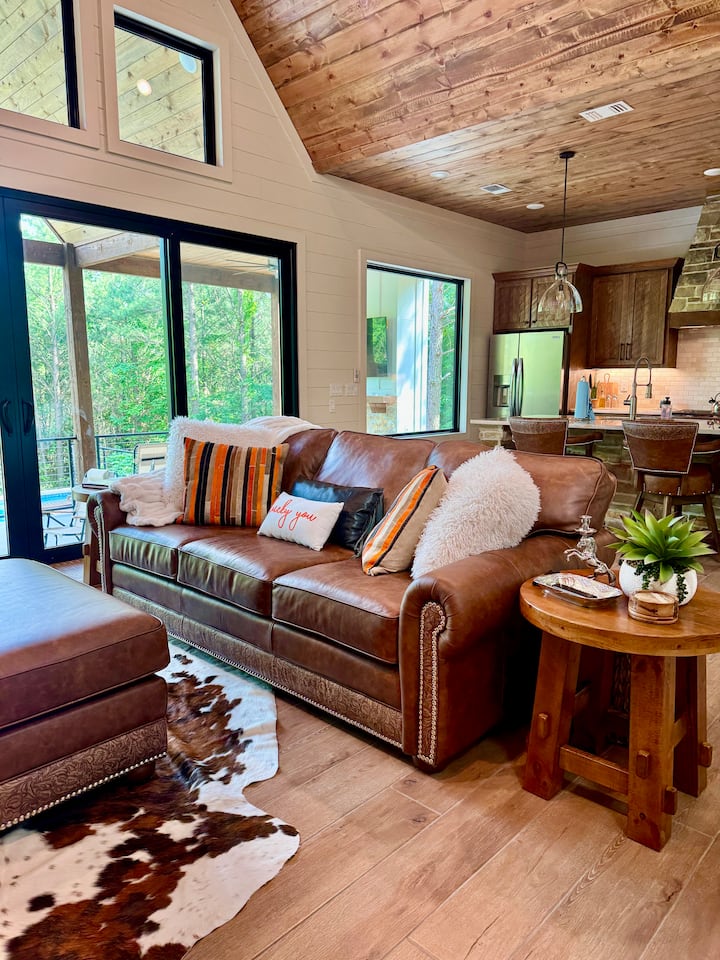 Relax and unwind at Saddle Up! Check out the LUX modern-western furnishings, heated pool, sauna, fire pit and the beautiful forest! Just a short walk to restaurants! Enjoy as a small family or a romantic getaway in Broken Bow/Hochatown, Oklahoma! 