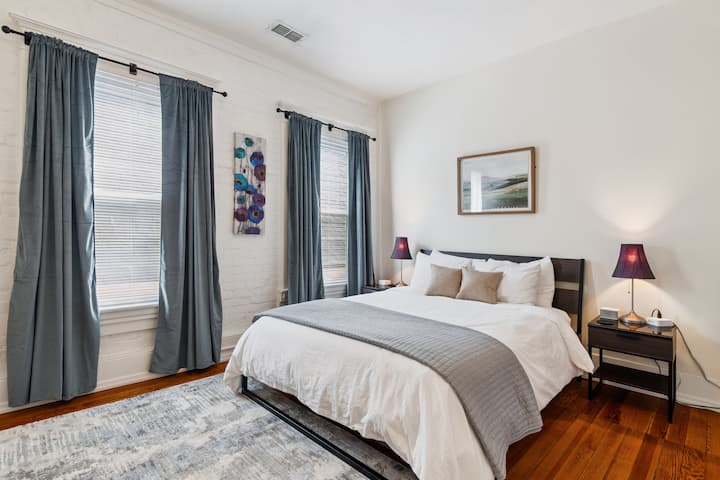 Spavajte mirno u ovoj svijetloj i elegantnoj spavaćoj sobi s bračnim krevetom, toplim drvenim podovima i živopisnim umjetničkim djelima koja stvaraju ugodan i srdačan ambijent.