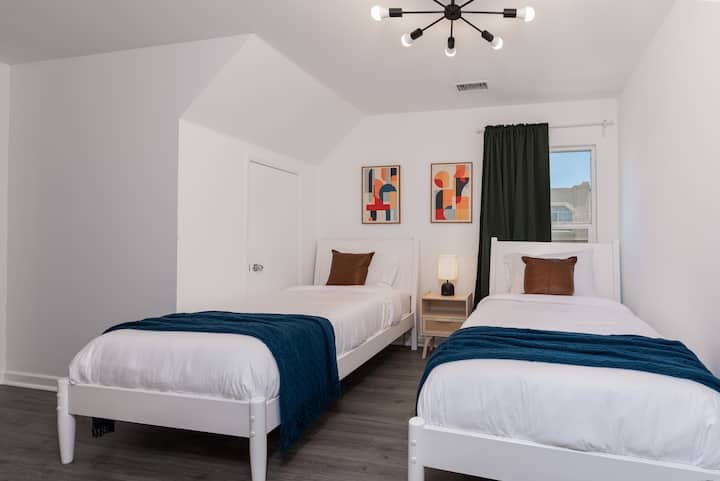 ห้องนอนสว่างและโปร่งสบายพร้อมเตียงแฝดสบายๆ 2 เหมาะสำหรับเพื่อนหรือครอบครัว มีการตกแต่งที่ทันสมัย ผ้าปูที่นอนนุ่ม และแสงธรรมชาติเข้ามาได้เพียงพอเพื่อการเข้าพักที่ผ่อนคลาย เหมาะสำหรับผู้ที่ต้องการความสะดวกสบายและมีสไตล์ในบรรยากาศอบอุ่น