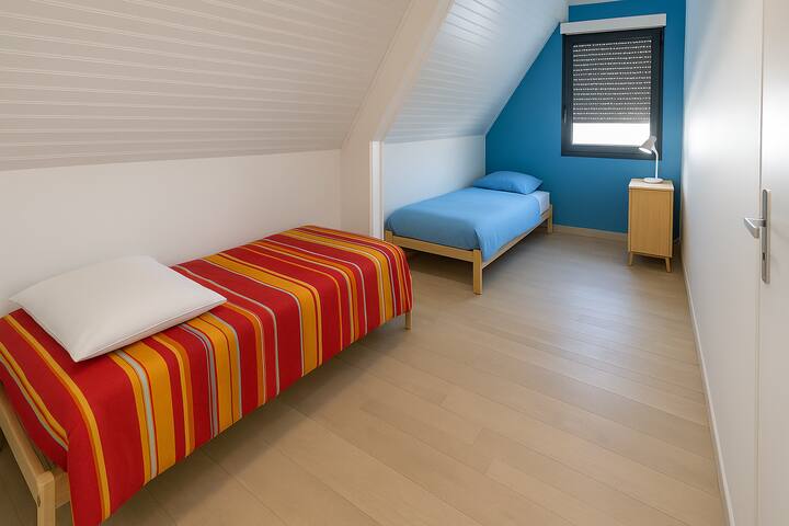 ห้องใต้หลังคาพร้อมเตียงเดี่ยวสองเตียง มีทีวีและเครื่องเล่นเกม Xbox เหมาะสำหรับเด็กหรือผู้ชื่นชอบวิดีโอเกม พื้นที่สบาย ๆ สำหรับการพักผ่อนอย่างอิสระ