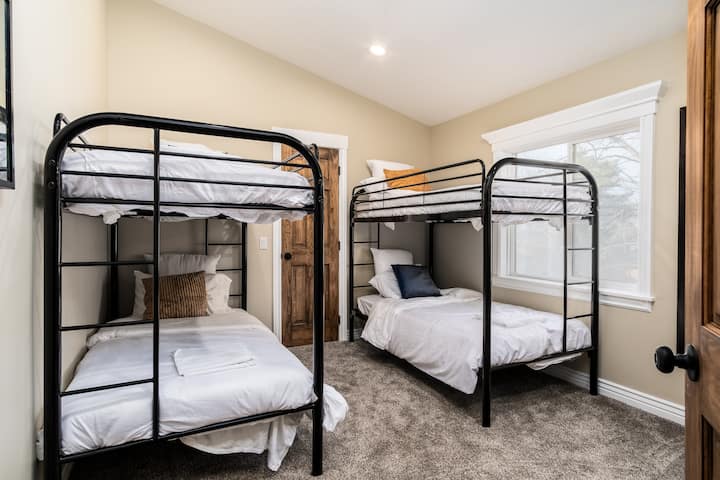 Spavaća soba na katu s dva odvojena kreveta povezana s kupaonicom koju dijele dvije sobe