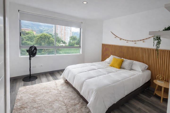 Quarto com cama de casal, ventilador de chão e armário