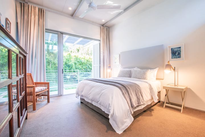 A房的第4间卧室配有一张标准双人床、充足的橱柜空间、一间套内卫生间、书籍和令人惊叹的花园景观，可欣赏到桌山。  