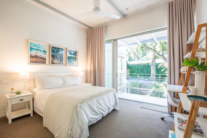 A房的第二间卧室配有一张双人床，面朝郁郁葱葱的花园和桌山。  配有遮光百叶窗、宽敞的橱柜空间、带淋浴间、浴缸和厕所的套房浴室。